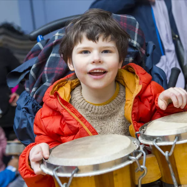 Evan playing the drums and smiling at LauraLynn
